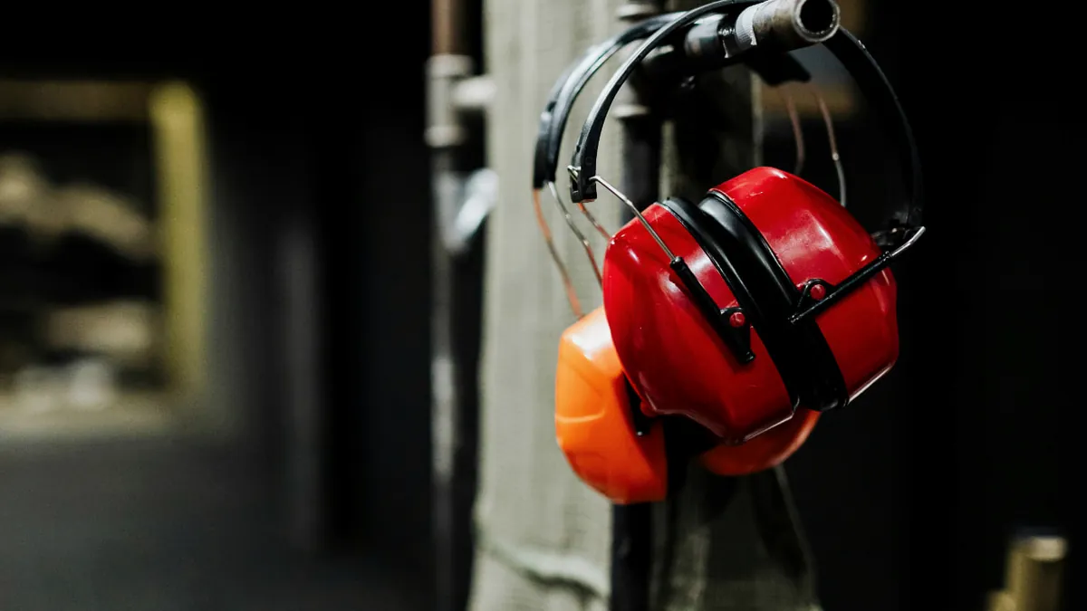 Protetores auriculares pendurados em bancada organizada de estande de tiro